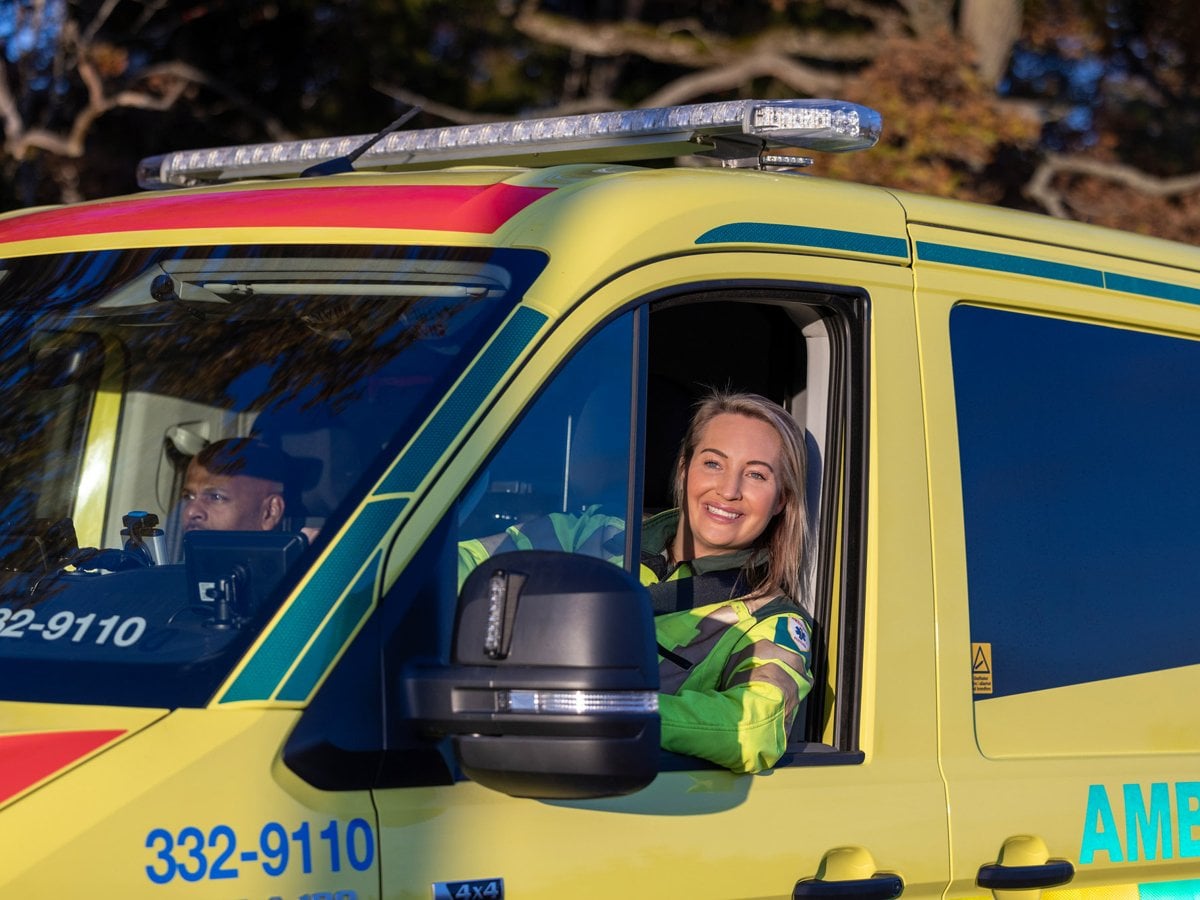 Sjuksköterska tittar ut från förarhytten på en ambulans